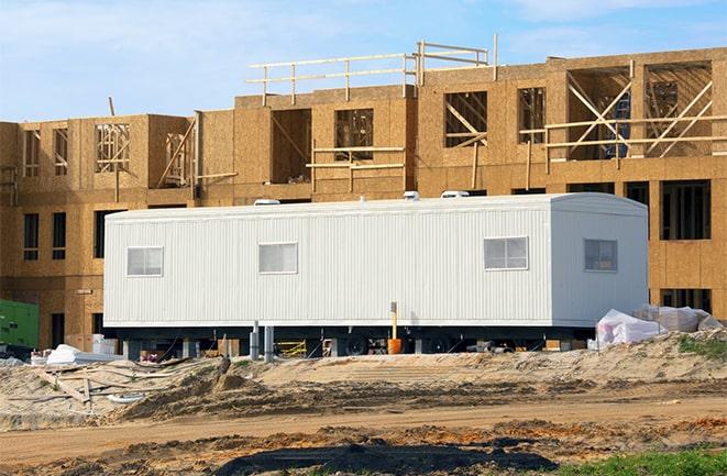 crane lifting modular building for construction office rentals in Clewiston